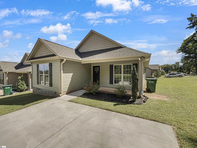 view of front of home with a porch, a front lawn, and a shingled roof