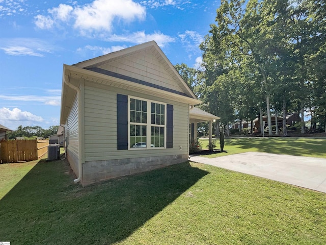 view of side of property with a lawn and fence