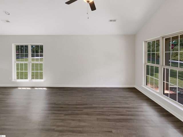 unfurnished room featuring lofted ceiling, dark wood-style floors, visible vents, and baseboards