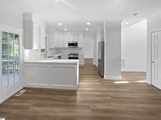 kitchen featuring visible vents, a sink, stainless steel appliances, white cabinets, and light countertops