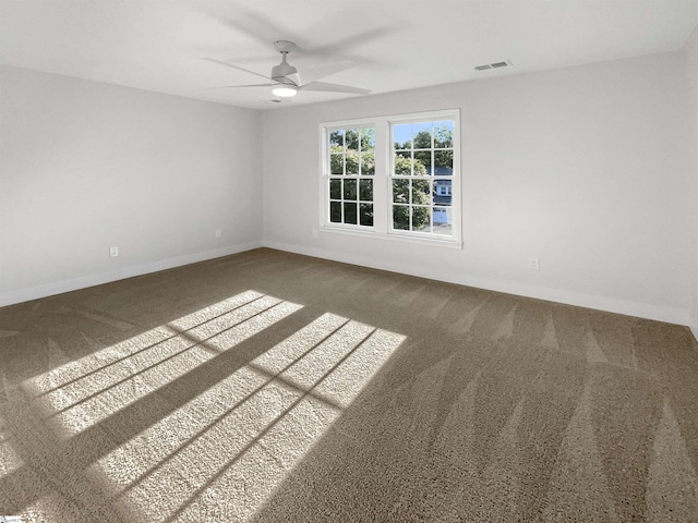 carpeted empty room featuring visible vents, baseboards, and a ceiling fan