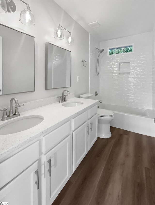 full bathroom featuring toilet, hardwood / wood-style flooring, bathing tub / shower combination, and vanity