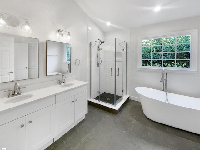 bathroom with a shower stall, a soaking tub, double vanity, and a sink