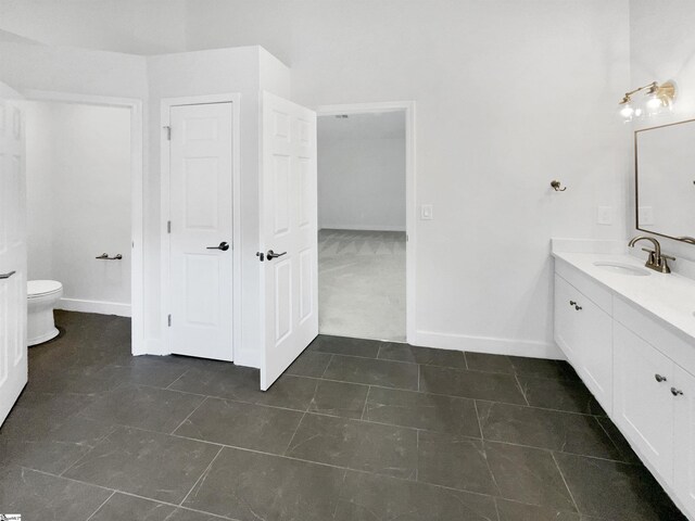 bathroom featuring vanity, toilet, and tile patterned flooring