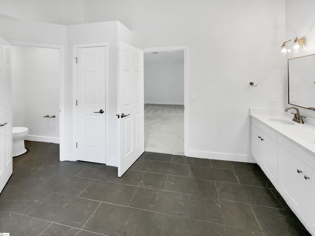 full bathroom with toilet, vanity, and baseboards