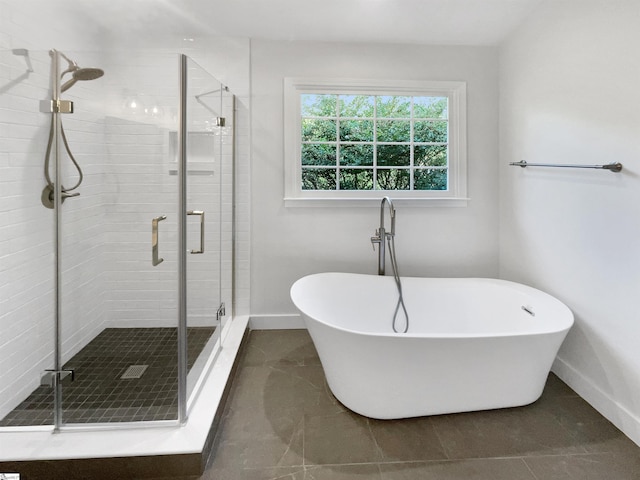 bathroom featuring a shower stall, baseboards, and a freestanding tub