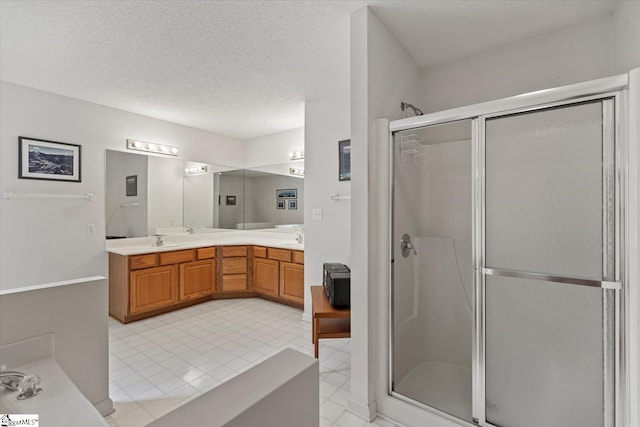 bathroom with vanity, a textured ceiling, and an enclosed shower