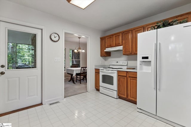 kitchen with a wealth of natural light, an inviting chandelier, decorative light fixtures, and white appliances