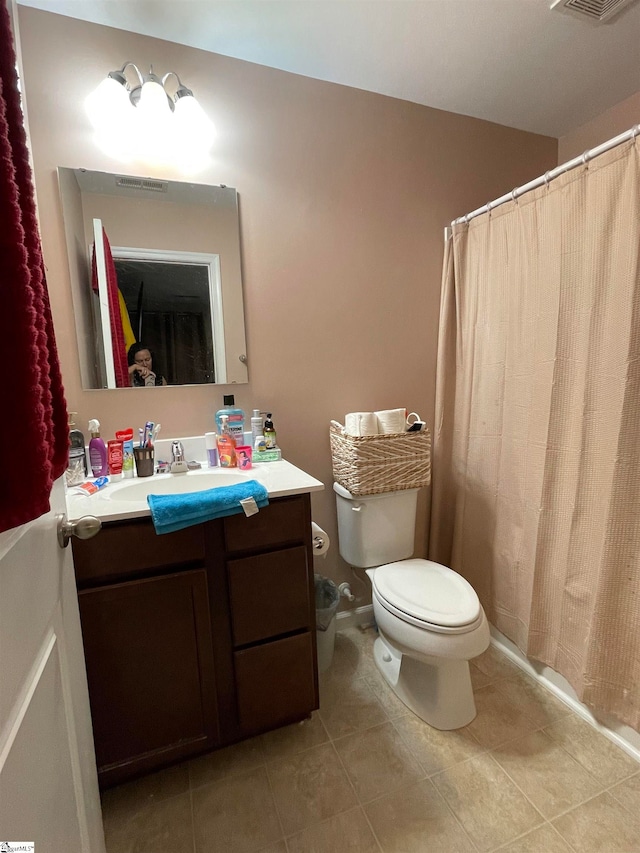 bathroom featuring toilet, vanity, and tile patterned flooring