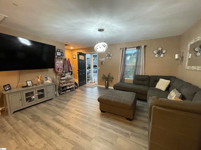 living room featuring light wood-type flooring and an inviting chandelier