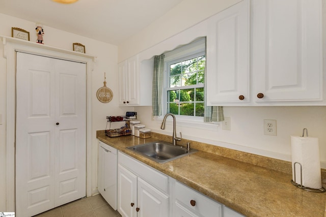 kitchen featuring light tile patterned floors, white cabinetry, sink, and white dishwasher