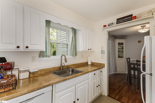 kitchen featuring white appliances, white cabinetry, wood-type flooring, and sink