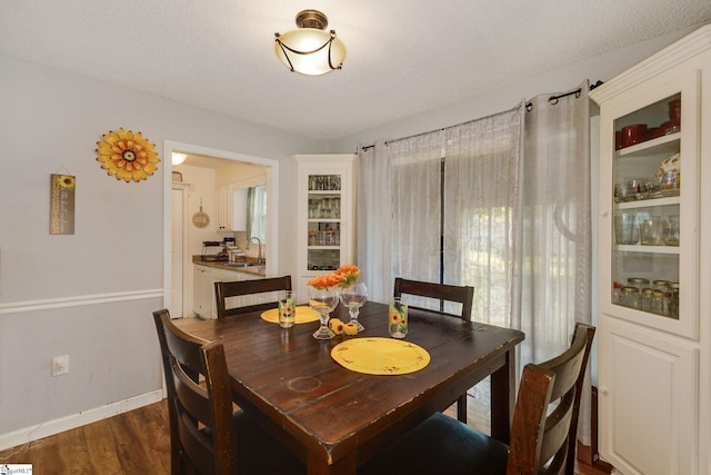 dining room with a textured ceiling, dark wood-type flooring, and sink