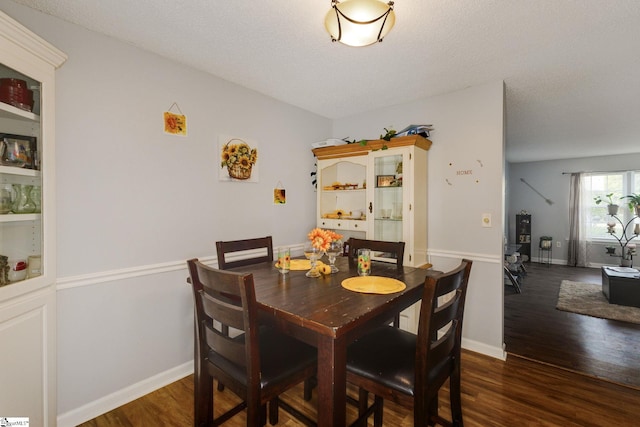 dining space featuring a textured ceiling and dark hardwood / wood-style floors