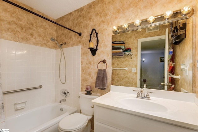 full bathroom with tiled shower / bath, toilet, a textured ceiling, and vanity