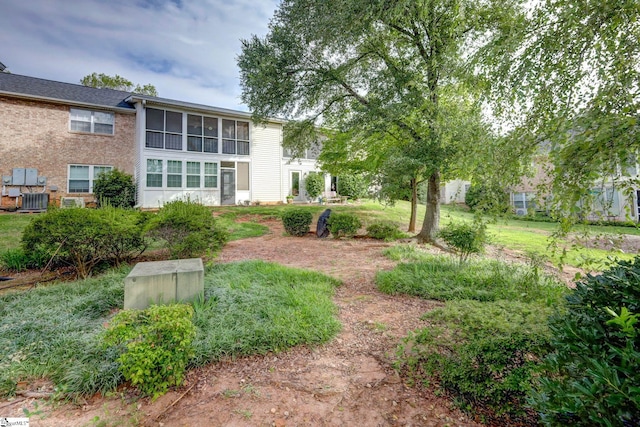 view of yard featuring central AC unit and a sunroom