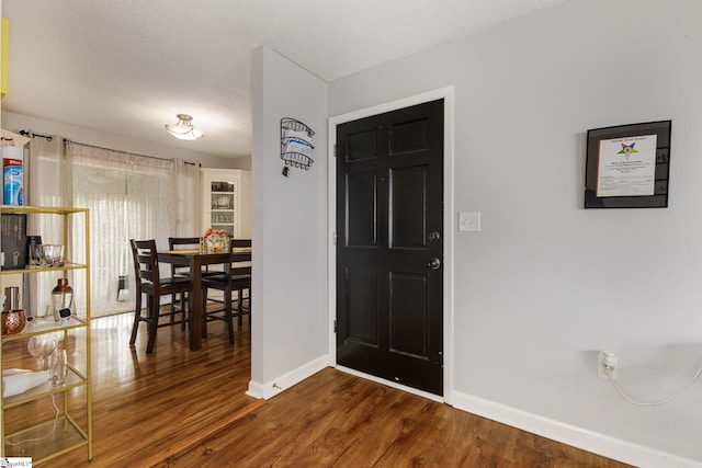 foyer with wood-type flooring and a textured ceiling