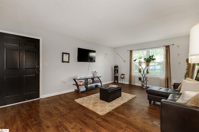 living room with dark wood-type flooring and a textured ceiling