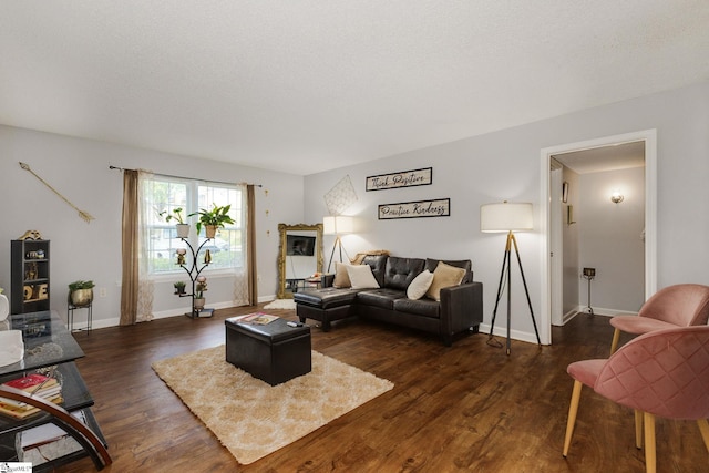 living room with a textured ceiling and dark hardwood / wood-style floors