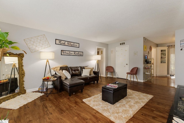 living room with a textured ceiling, a high end fireplace, and dark hardwood / wood-style flooring