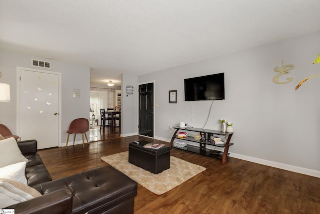 living room with dark hardwood / wood-style floors and a textured ceiling