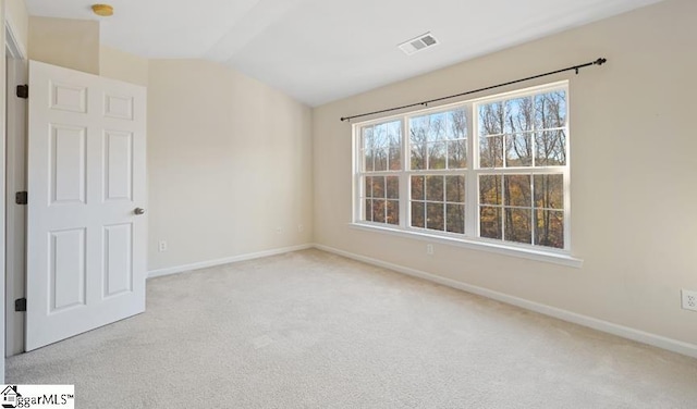 carpeted empty room with lofted ceiling