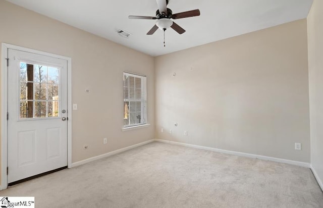 empty room featuring light colored carpet and ceiling fan