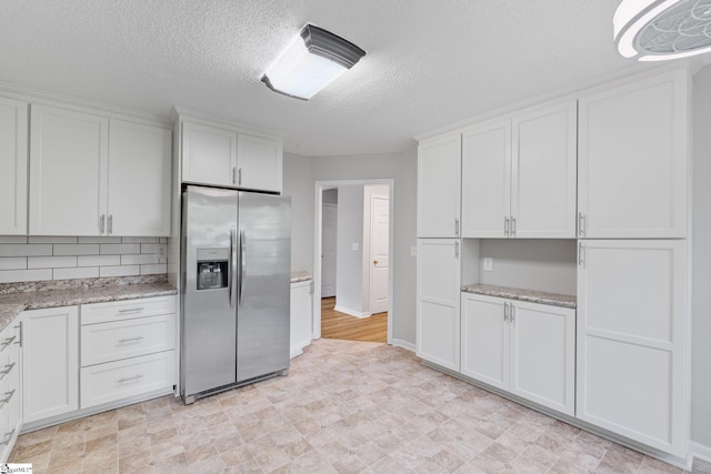 5 Townes Creek Ct, Greenville, SC 29609 - kitchen with light stone countertops, white cabinetry, stainless steel refrigerator with ice dispenser, and a textured ceiling