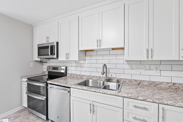 kitchen featuring sink, a textured ceiling, appliances with stainless steel finishes, tasteful backsplash, and white cabinetry