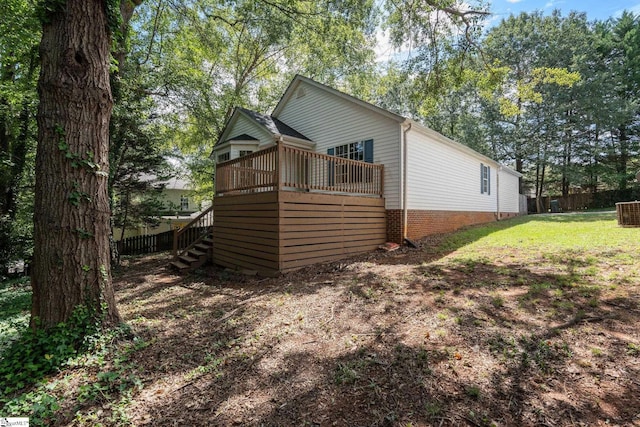 view of side of home featuring a lawn and a wooden deck