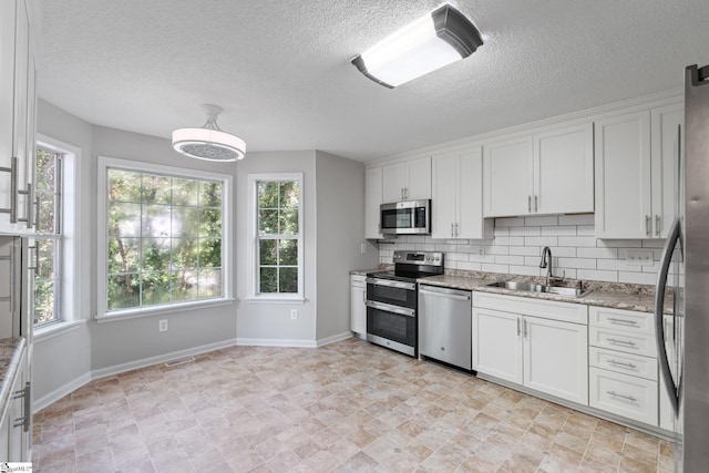 5 Townes Creek Ct, Greenville, SC 29609 - kitchen with white cabinets, baseboards, a sink, and appliances with stainless steel finishes
