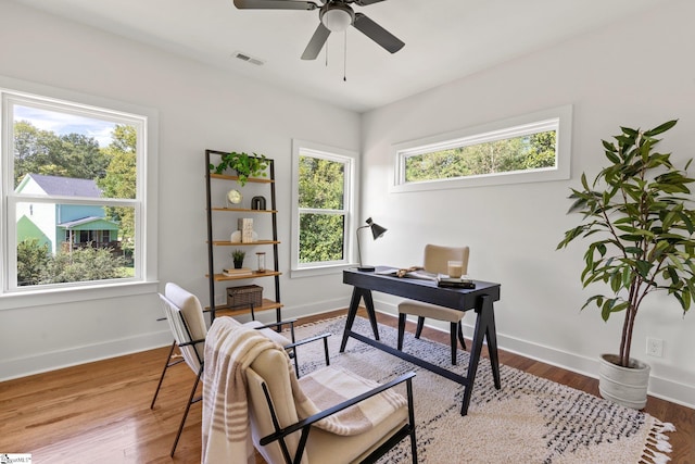 home office with hardwood / wood-style floors and ceiling fan