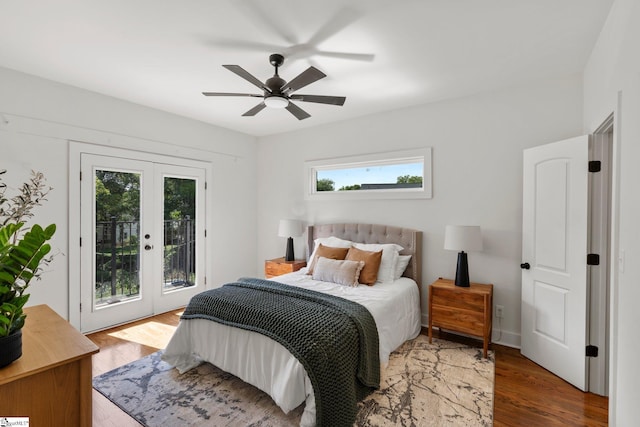 bedroom featuring multiple windows, hardwood / wood-style flooring, access to exterior, and ceiling fan