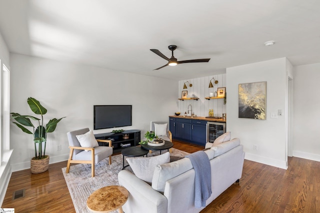 living room featuring beverage cooler, ceiling fan, dark hardwood / wood-style floors, and wet bar