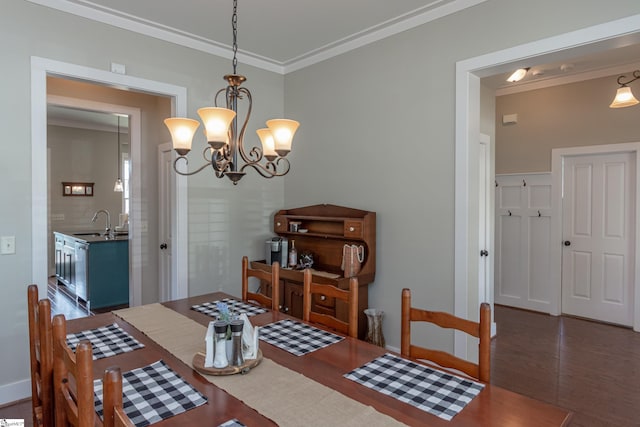 dining room with a notable chandelier, sink, and ornamental molding