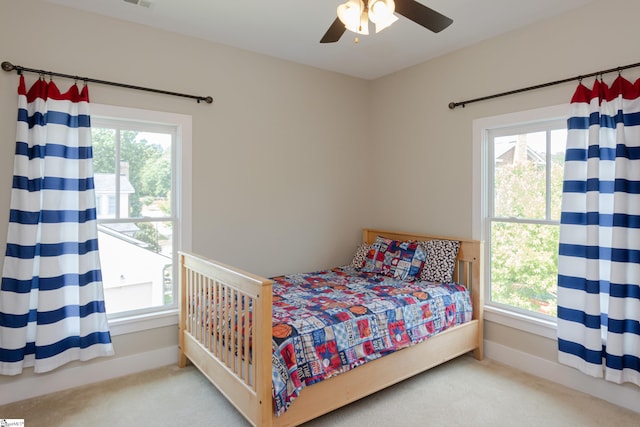 bedroom featuring ceiling fan, carpet floors, and multiple windows