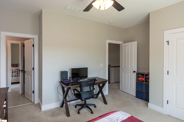 carpeted office space with ceiling fan