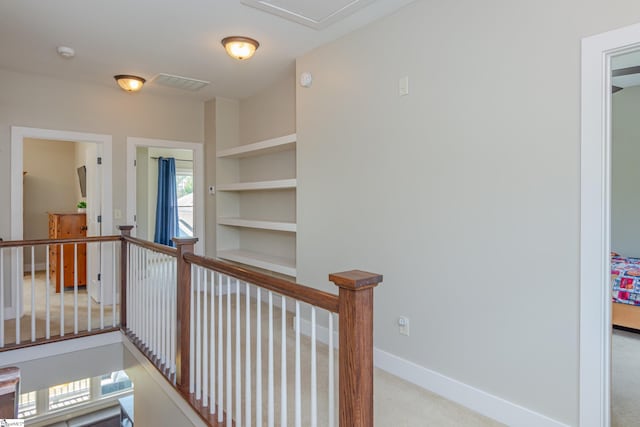 hall with light colored carpet