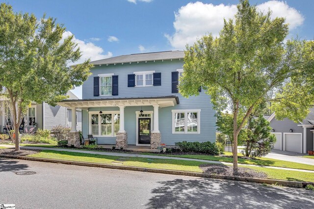 back of property featuring ceiling fan, a patio area, a lawn, covered porch, and a garage