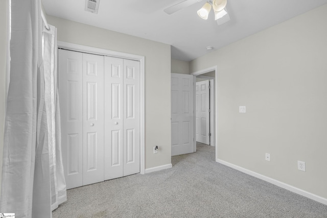 unfurnished bedroom with a closet, ceiling fan, and light carpet