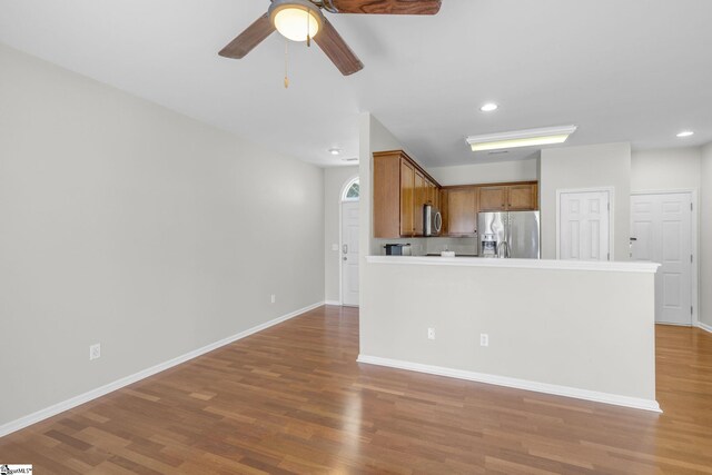 kitchen with appliances with stainless steel finishes, wood-type flooring, and ceiling fan