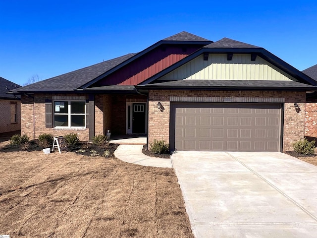 view of front of house featuring a garage, roof with shingles, concrete driveway, and brick siding