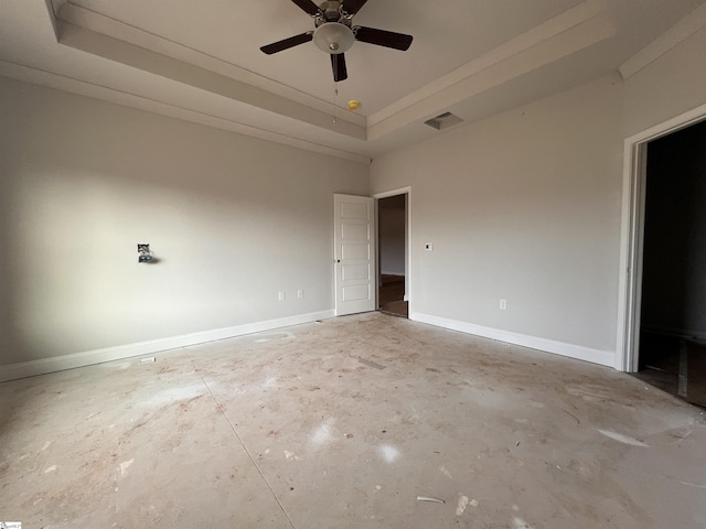 spare room featuring a tray ceiling, unfinished concrete flooring, visible vents, ceiling fan, and baseboards