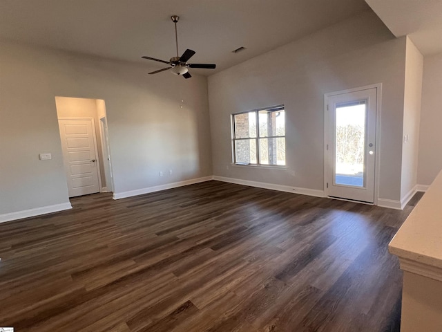 unfurnished living room featuring visible vents, dark wood finished floors, baseboards, and ceiling fan