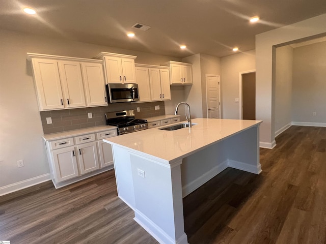 kitchen featuring stainless steel appliances, a sink, visible vents, white cabinets, and dark wood finished floors