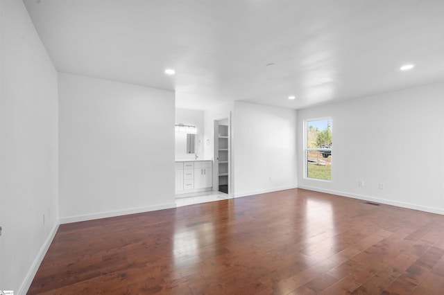 unfurnished living room with recessed lighting, wood-type flooring, visible vents, and baseboards