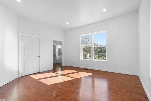 unfurnished bedroom featuring baseboards, hardwood / wood-style floors, and recessed lighting