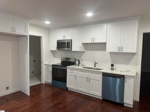 kitchen featuring sink, dark hardwood / wood-style floors, decorative backsplash, white cabinets, and appliances with stainless steel finishes