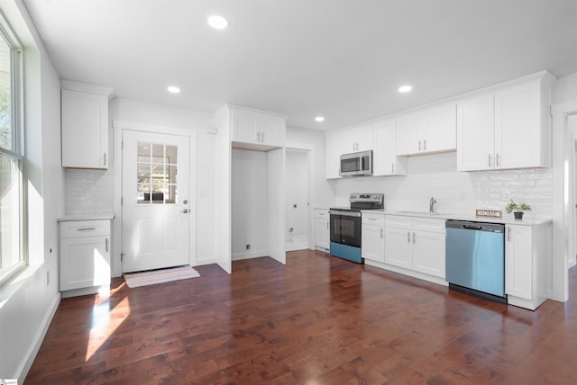 kitchen with dark wood-style flooring, stainless steel appliances, recessed lighting, light countertops, and white cabinetry