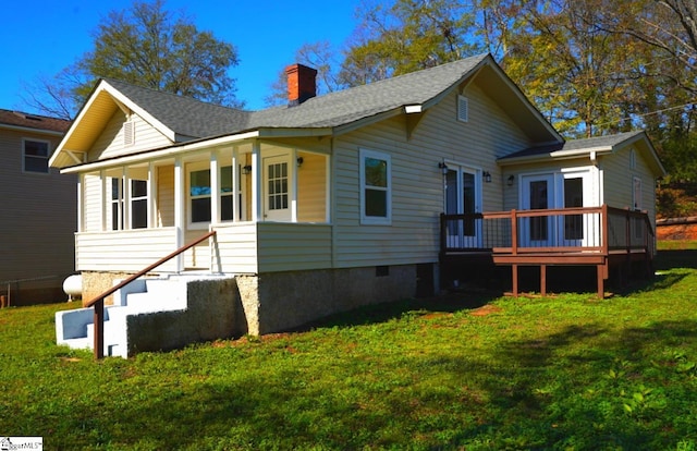 back of property featuring crawl space, roof with shingles, a yard, and a chimney